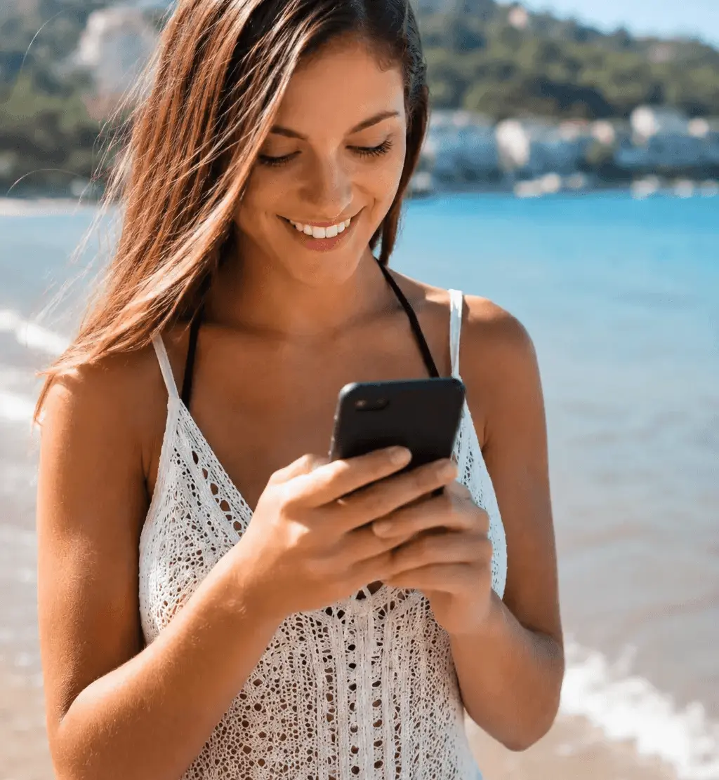 Ragazza sorridente mentre guarda lo smartphone